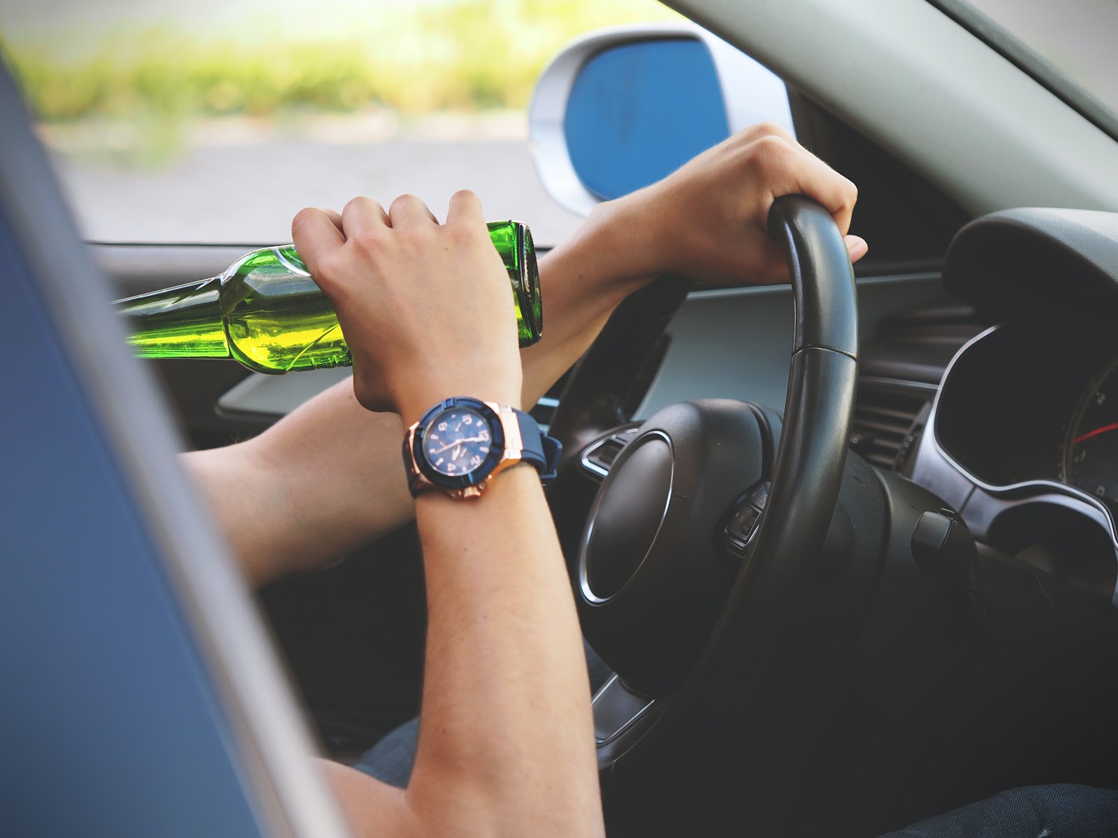 A man drinking beer while driving